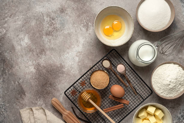 istock Baking ingredients and cooling rack on rustic beige background. View from above. 1304012840
