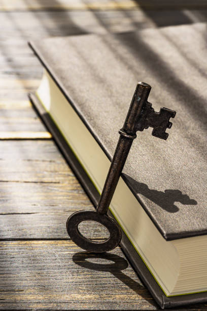 istock Vintage key and hardback book on wooden table 1304013942
