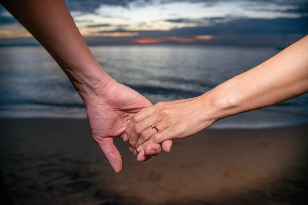 istock couple holding hand walking near the beach 1304014120