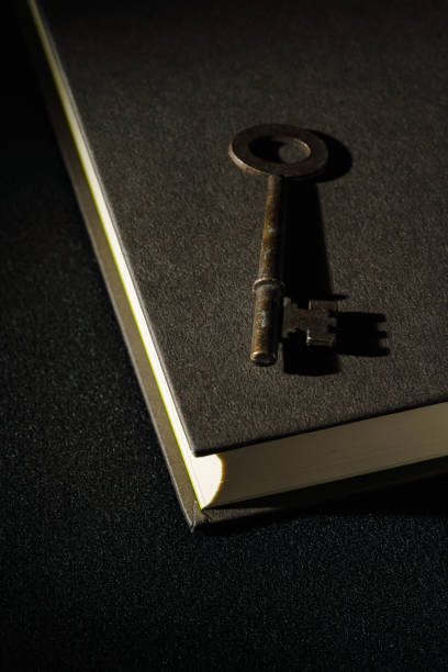 istock Vintage key and hardback book on dark background 1304014251