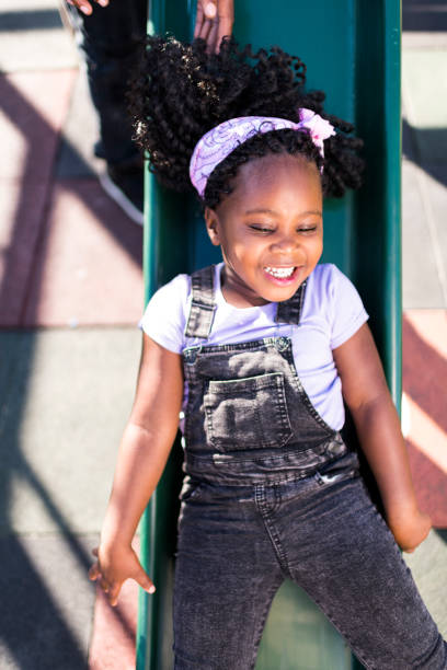 istock Little girl sliding down slide in a park 1304015345