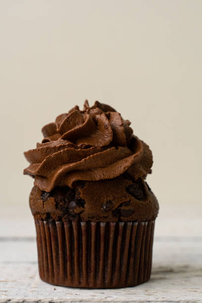 istock chocolate cupcake with whipped chocolate cream. decorated with ochocolate drops. Rustic wood background 1304015752