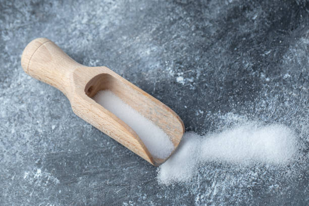 istock Salt in a wooden spoon on a marble background 1304021262
