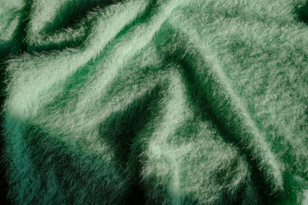 istock Green fluffy soft textile background with drapers. Top view. Copy space. fashion, style, elegance concept 1304021491