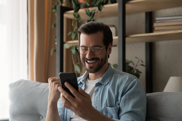 istock Overjoyed young man reading email with job offer on cell 1304021748