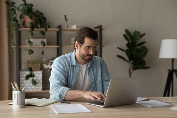 istock Focused young businessman freelancer engaged in distant work on laptop 1304021784