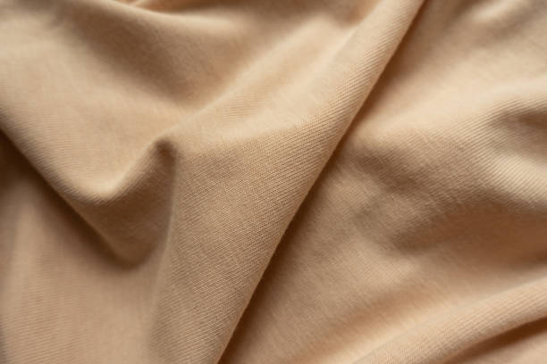 istock Light brown cotton jersey fabric in soft folds 1304023147
