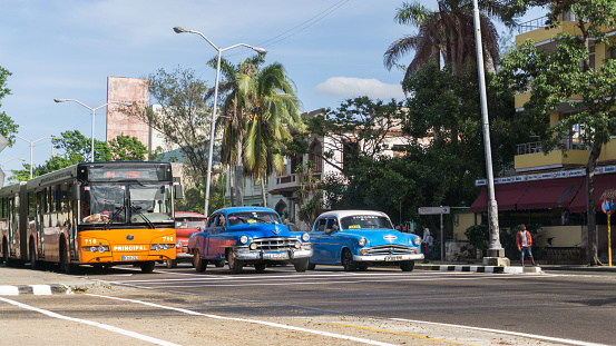 Havana, Cuba-December 11/2017: Authentic view of traffic on the streets of Havana of an old, classic, vintage car glowing on a beautiful sunny day where you can see a mixture of old and new. Visit Havana