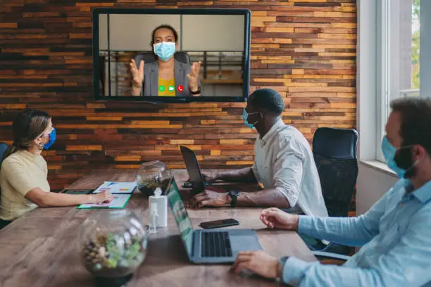 Photo of Business people meeting on video call in the office during COVID-19 pandemic