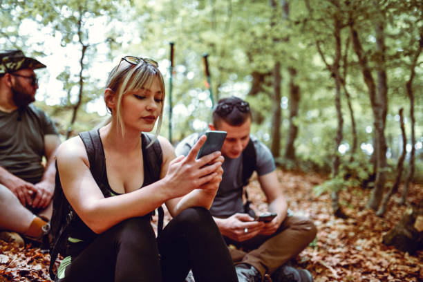 istock Cute Female Browsing Through Forest Photos While Hiking With Friends 1304031795