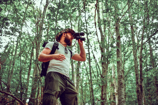 istock Modern Hiker Using Binoculars To Search For New Route While Walking In Forest 1304031960