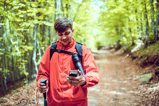 Smiling Male Hiker Using Smartphone GPS To Find His Way To Closes Summit