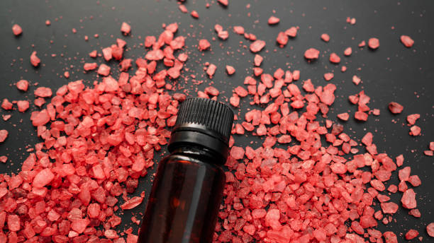istock Beautiful spa composition with vial and sea salt for bath on black background 1304034317