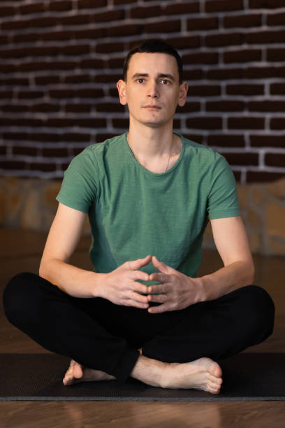 istock Young man meditating with his eyes open, practicing yoga with hands in prayer position 1304035674