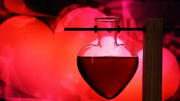 Open heart-shaped bottle of red love potion on a blurred black and red background