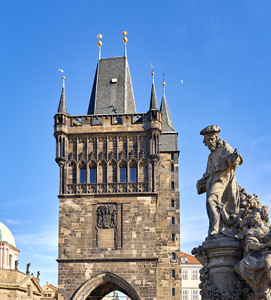 Prague, Czech Republic - March 2, 2020 Baroque statue on Charles Bridge and Old town bridge tower