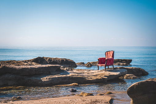 Lonely vintage armchair on a rocky coast
