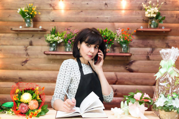 istock Florist in the workplace talking to clients on the phone 1304041849