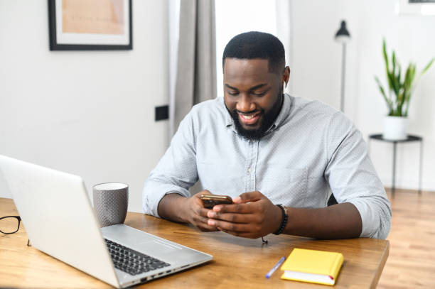 istock Happy smiling Afro American guy looking on phone 1304043609