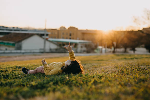 istock Child Lying On Field Against Sky 1304044136