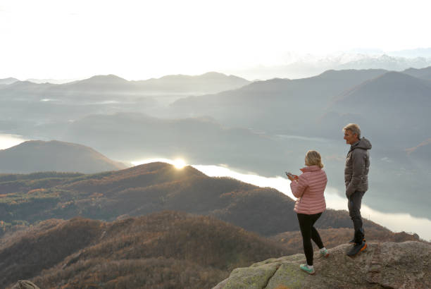 istock Couple with smart phone stand on cliff edge 1304044974