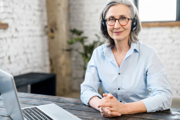 istock Senior female office worker wearing a headset 1304046565