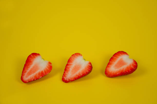 istock Three strawberries lying on the yellow background 1304046758