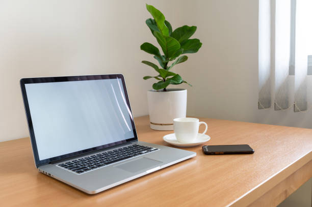 istock White screen Laptop computer with monstera plant, coffee cup and smart phone on wooden table 1304047703