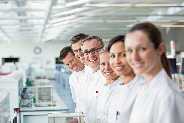 gli scienziati sorridenti insieme in laboratorio - research smiling scientist women foto e immagini stock