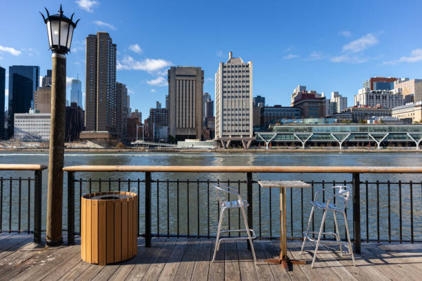 istock Empty Table and Chairs along the Roosevelt Island Riverfront with the Upper East Side Skyline in New York City in the Background 1304047975