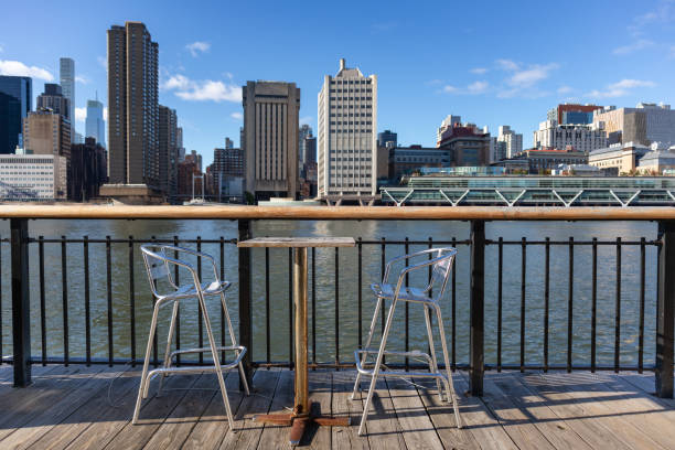 istock Empty Table and Chairs along the Roosevelt Island Riverfront with the Upper East Side Skyline in New York City in the Background 1304047983