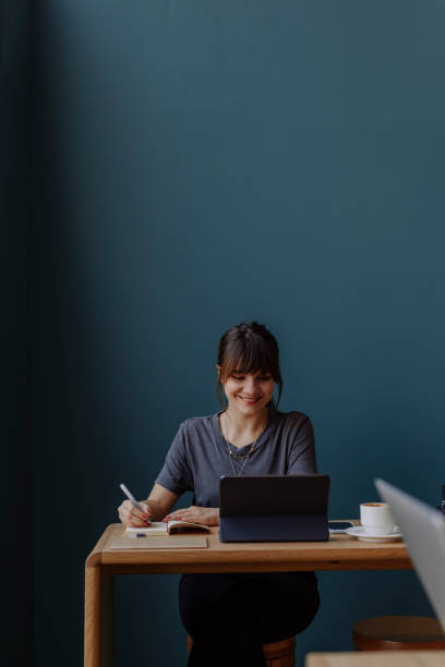 istock Women in Business: a Smiling Young Businesswoman Using a Digital Tablet at her Office 1304049593