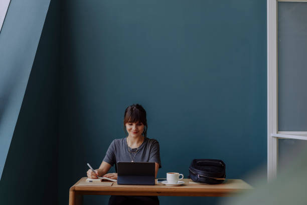 istock Women in Business: a Smiling Young Businesswoman Using a Digital Tablet at her Office 1304049598