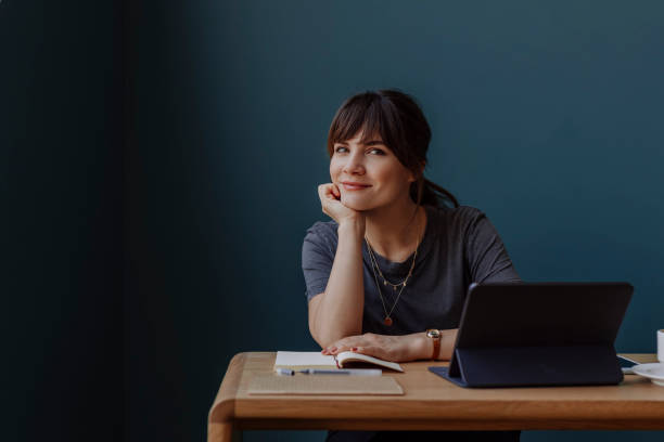 istock Women in Business: a Smiling Young Businesswoman Using a Digital Tablet at her Office 1304049604