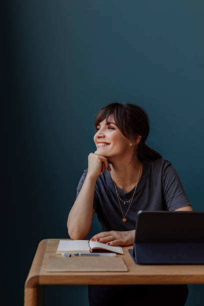 istock Women in Business: a Smiling Young Businesswoman Using a Digital Tablet at her Office 1304049628