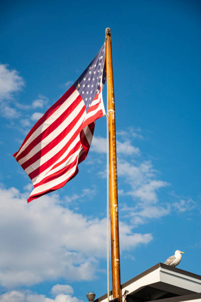 istock American flag on the blue and cloudy sky 1304051853