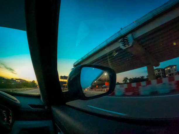 A rear mirror of a car showing beautiful sunset