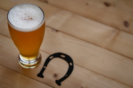 Full pitcher of beer close up on wooden table with copy space