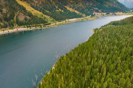 Aerial above winding road next to lake in Montana