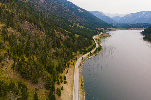 Aerial above winding road next to lake in Montana