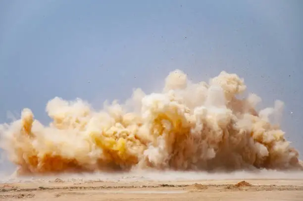 Dust clouds and flying rock particles during detonator blast in the desert