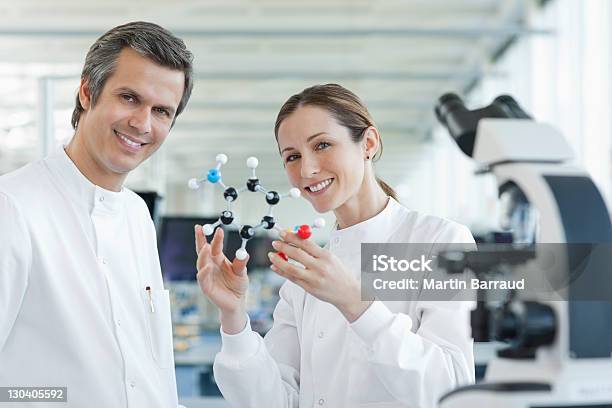 Scientists Examining Molecular Model In Lab Stock Photo - Download Image Now - Holding, Lab Coat, Model - Object