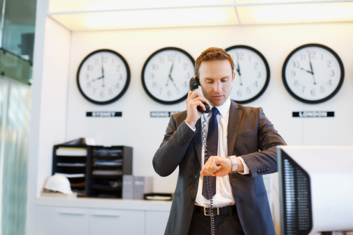 businessman's hand holding and assemble wooden cube with icon alarm clock shape. The concept of saving time on work to reduce costs.