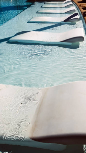 istock Loungers in swimming pool on sunny day 1304057585
