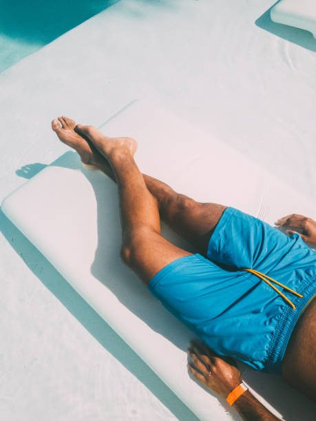 istock Crop man resting on lounger at poolside 1304057616