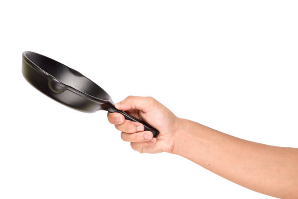 istock Iron cast skillet in hand isolated on white background with clipping path, tossing empty pan 1304058815