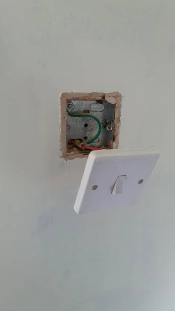 istock Light switch hanging of a wall during decoration 1304060601