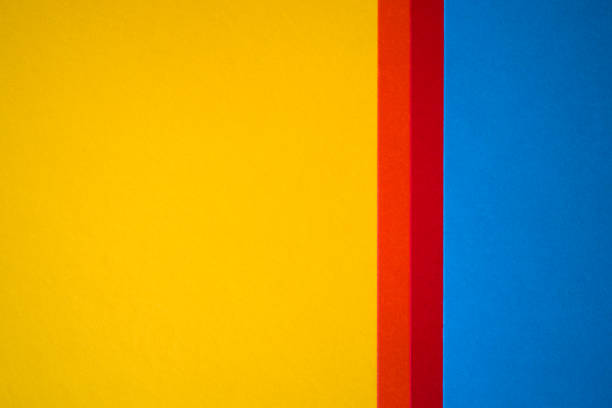istock Yellow and blue decorative colored paper textured background with copy space divided with orange and red stripes 1304060611