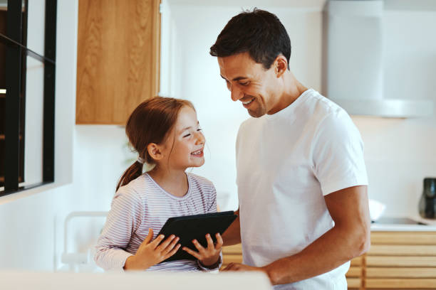 istock Laughing dad and girl using a tablet 1304061481