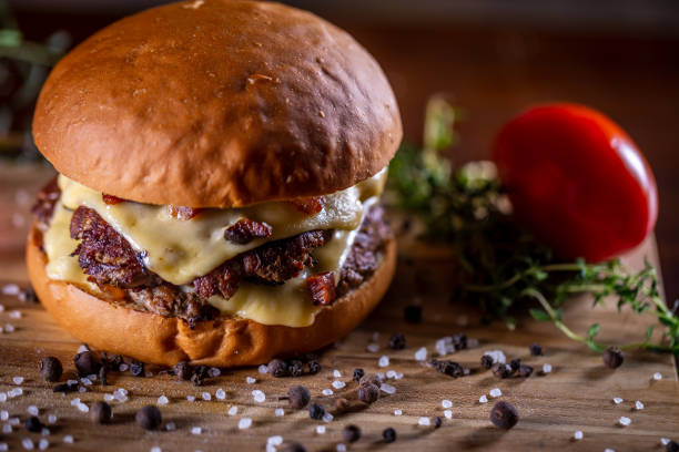 istock Craft beef smash burger with cheese, bacon and sauce on wooden background 1304061852
